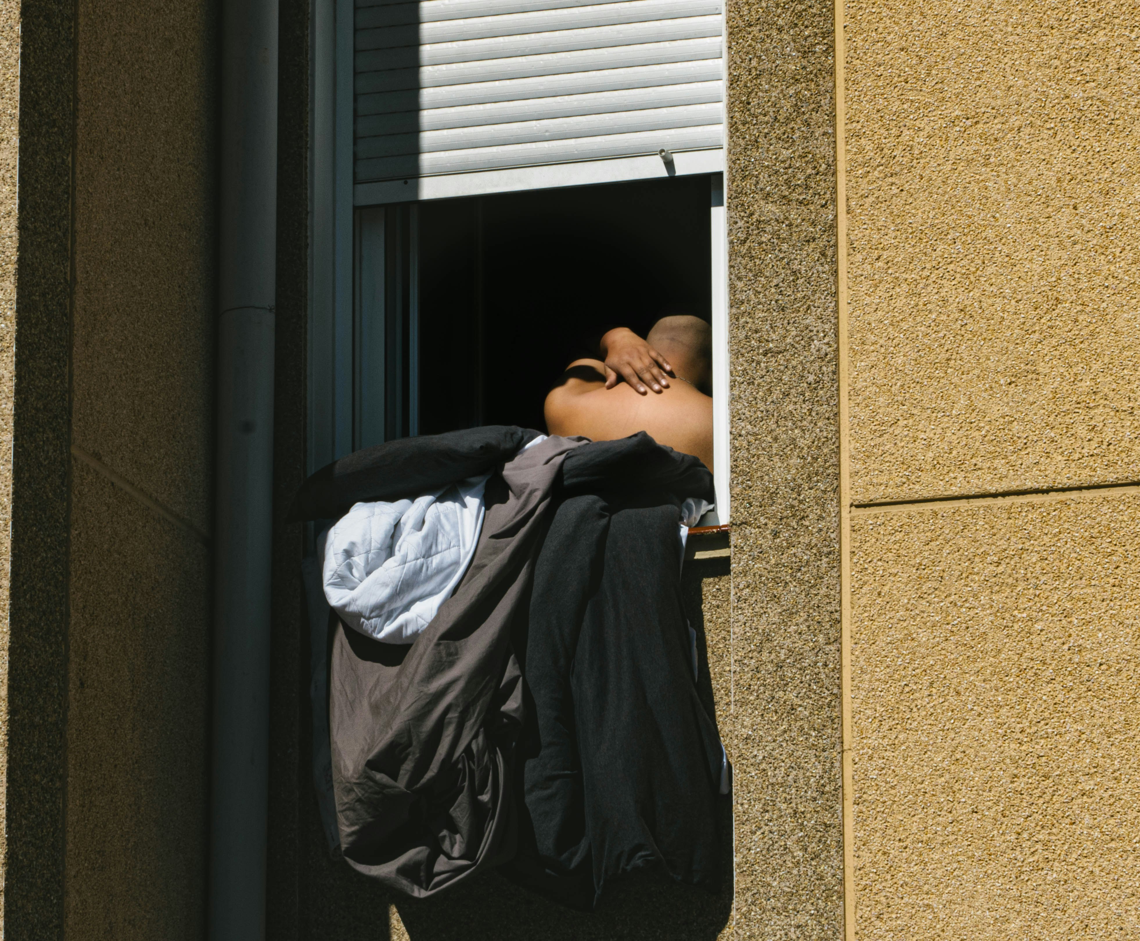 man in black t-shirt lying on black wooden door